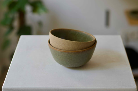Stack of ceramic bowls on a white surface with a blurred background