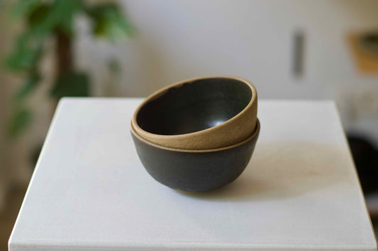 Two stacked ceramic bowls on a white surface with a blurred background