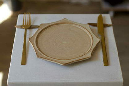 Wooden plate with gold fork and knife on a white surface